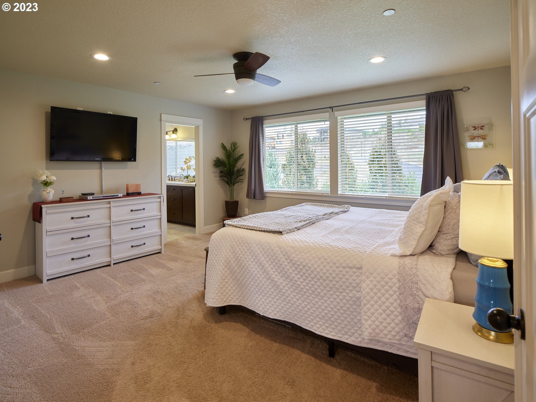 1424 Northwest Goodwin Street Camas, WA 98607 - Photo 20 of 40 a bedroom with a large bed and a flat tv screen on dresser