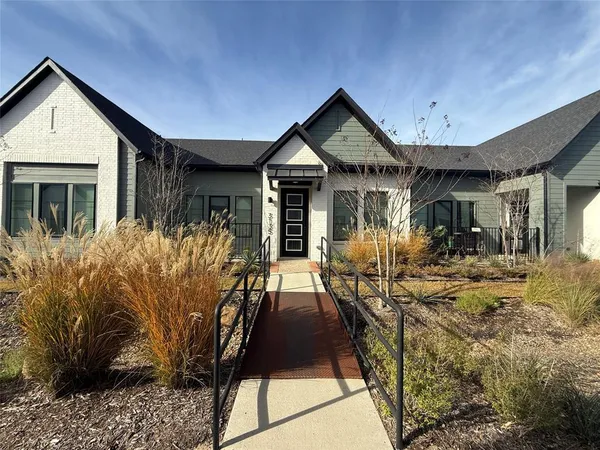 a front view of house with yard and trees in the background