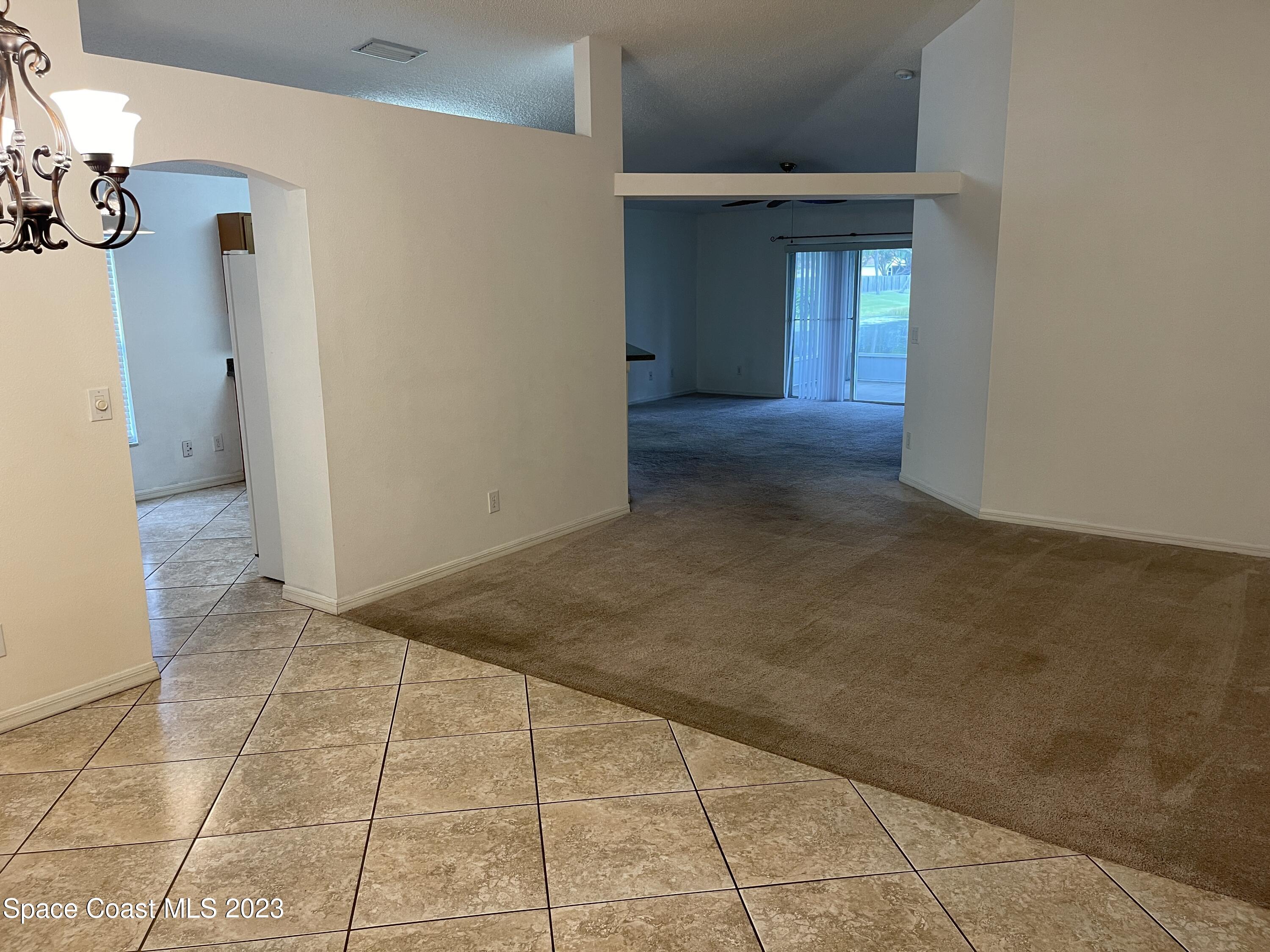 527 Melanie Circle Melbourne, FL 32901 - Photo 3 of 18 a view of a hallway with wooden floor and a living room