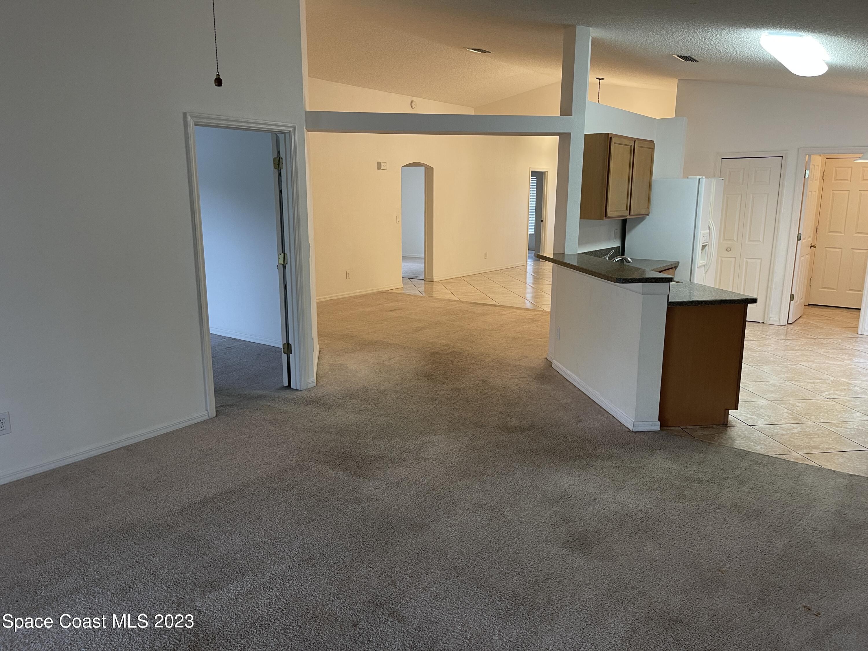 527 Melanie Circle Melbourne, FL 32901 - Photo 6 of 18 a view of a refrigerator in kitchen and living room
