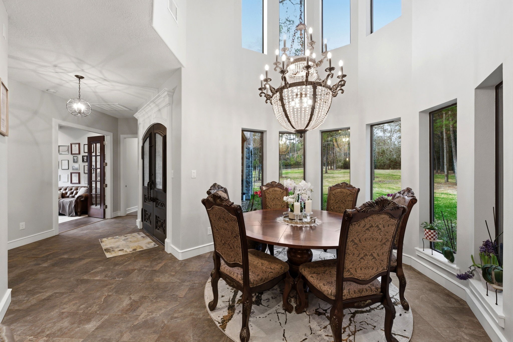 280 Sundog Road Huntsville, TX 77340 - Photo 7 of 50 Just beyond the entry, the dramatic two-story dining room features a curved wall of windows, striking chandelier, and soaring ceiling that fills the space with natural light.