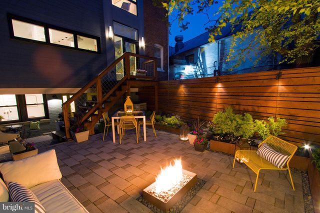 a view of a patio with table and chairs potted plants and large tree