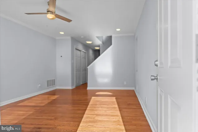 a view of a hallway with wooden floor and staircase