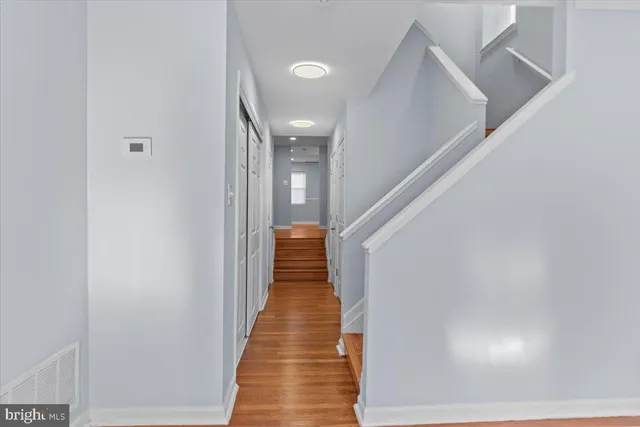 a view of a hallway with wooden floor and staircase