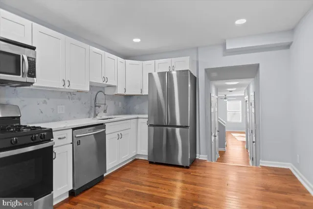 a kitchen with white cabinets and stainless steel appliances