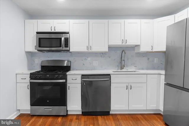 a kitchen with white cabinets and stainless steel appliances