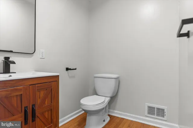a bathroom with a toilet a sink and mirror