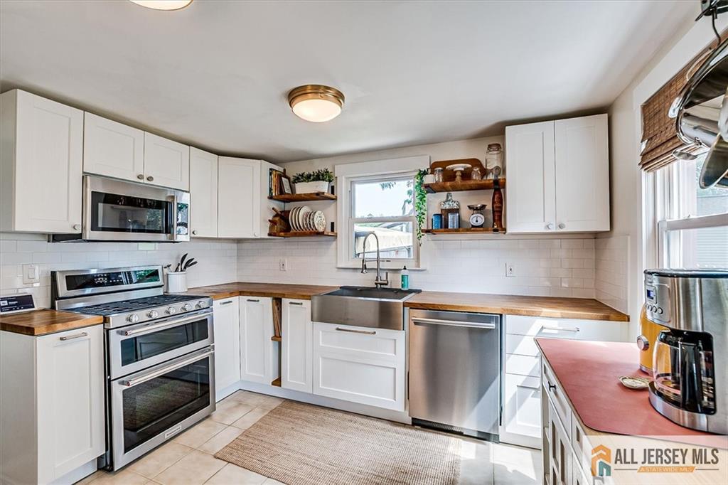 121 East Cliff Road Colonia, NJ 07067 - Photo 15 of 35 a kitchen with stainless steel appliances granite countertop a stove and a sink