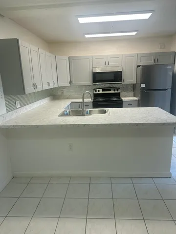 a kitchen with stainless steel appliances a sink a stove a microwave and cabinets