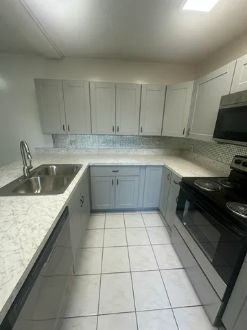 a kitchen with a sink a stove and cabinets