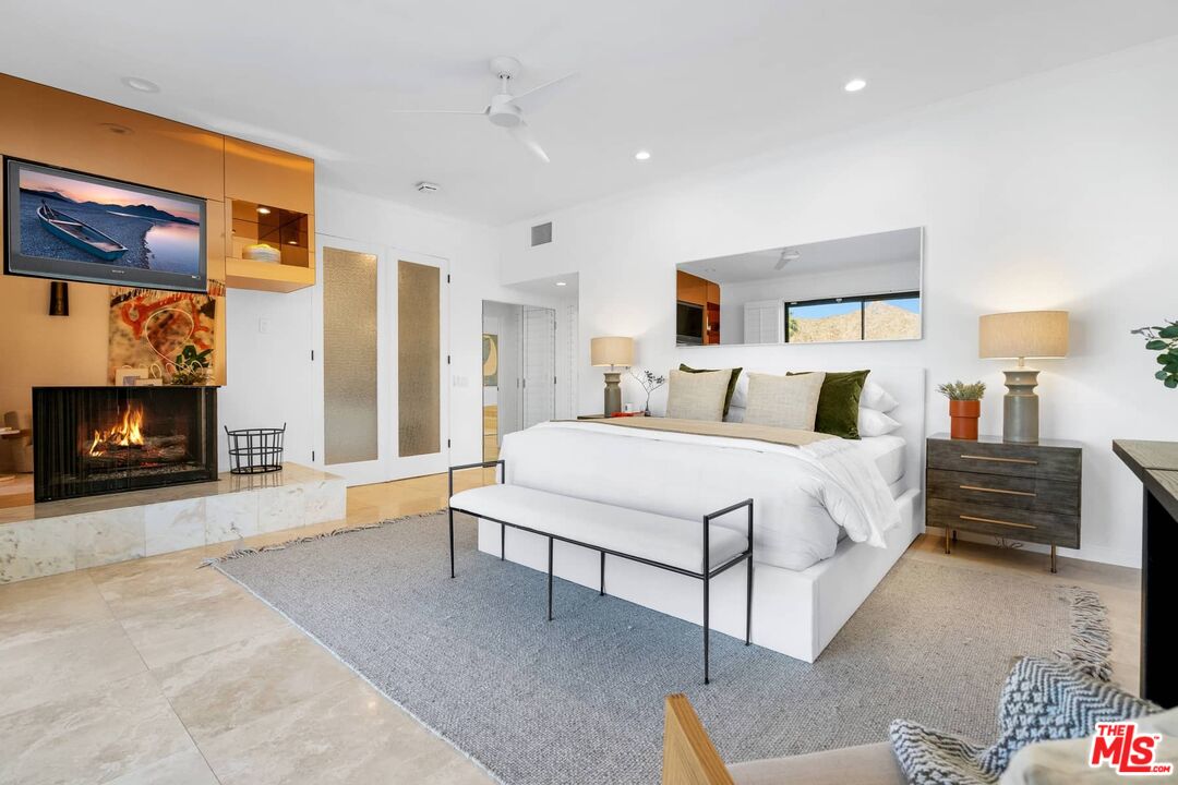 70255 Thunderbird Road Rancho Mirage, CA 92270 - Photo 38 of 53 a spacious bedroom with a bed and a fireplace