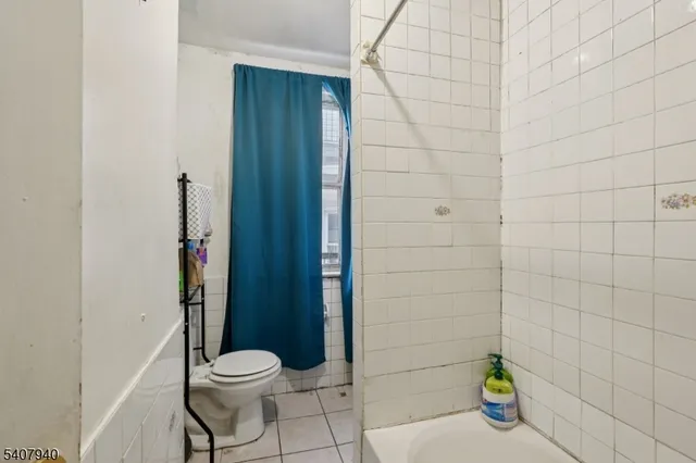 a kitchen with a refrigerator a sink dishwasher a dining table and chairs with wooden floor