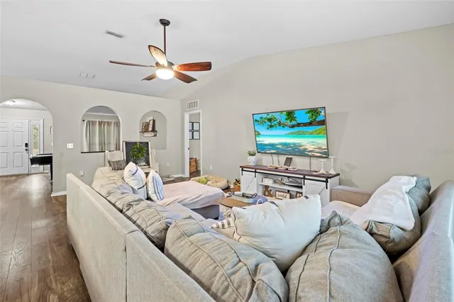 a living room with furniture a rug and kitchen view