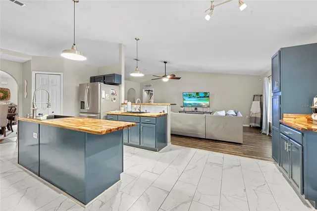 a kitchen with stainless steel appliances granite countertop a sink and a wooden floor
