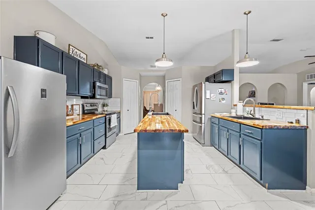 a kitchen with kitchen island granite countertop stainless steel appliances and wooden cabinets