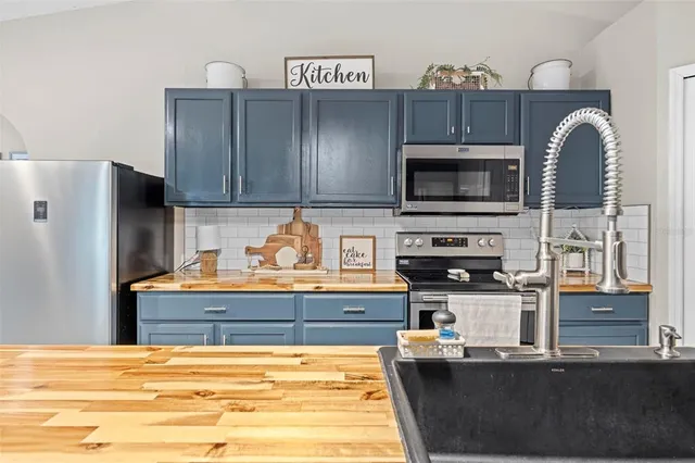 a large kitchen with stainless steel appliances granite countertop a large counter top and a stove