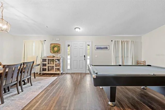 a living room with a table chairs and a wooden floor