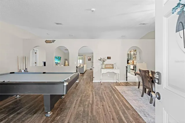 a living room with furniture a rug appliances and a wooden floor