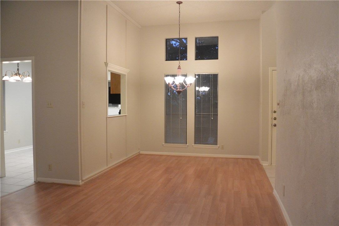 4902 Smokey Valley, Unit A Austin, TX 78731 - Photo 8 of 19 Formal dining room with laminate floors and chandelier. Pass through to kitchen on left.
