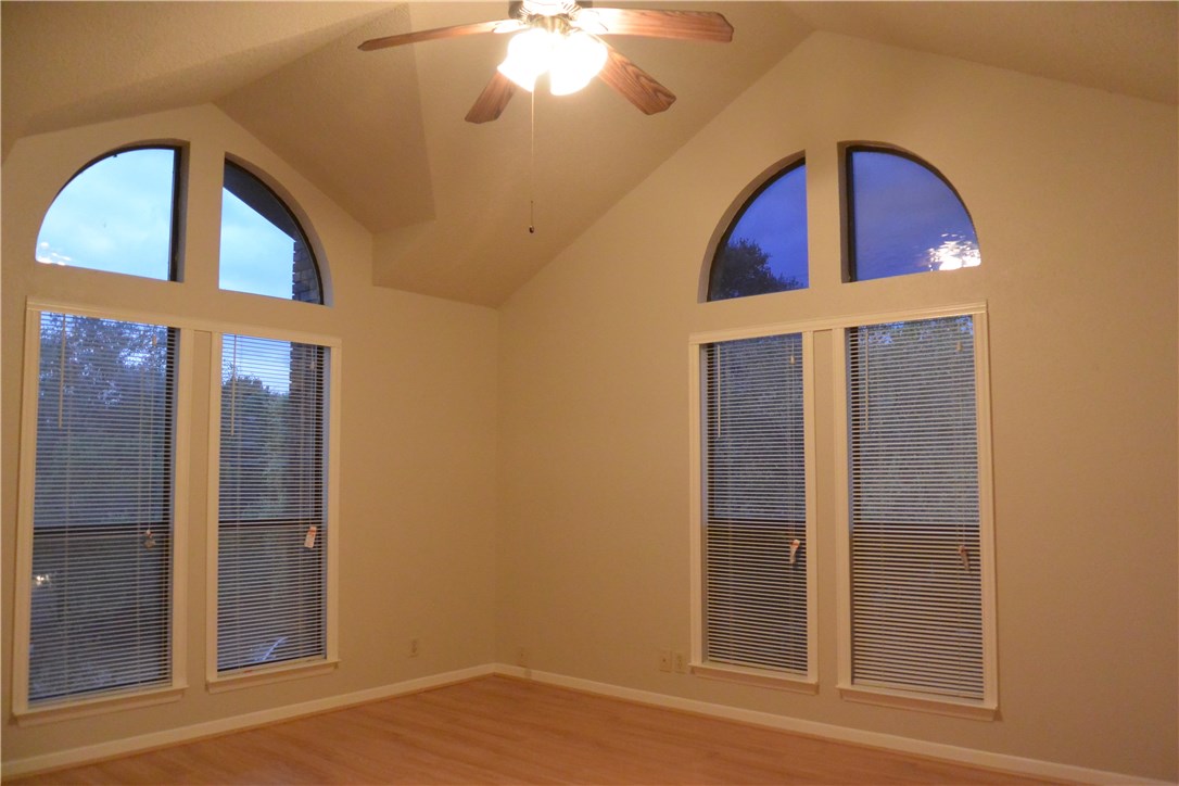 4902 Smokey Valley, Unit A Austin, TX 78731 - Photo 9 of 19 Upstairs master bedroom has vaulted ceiling with lots of windows and a ceiling fan.