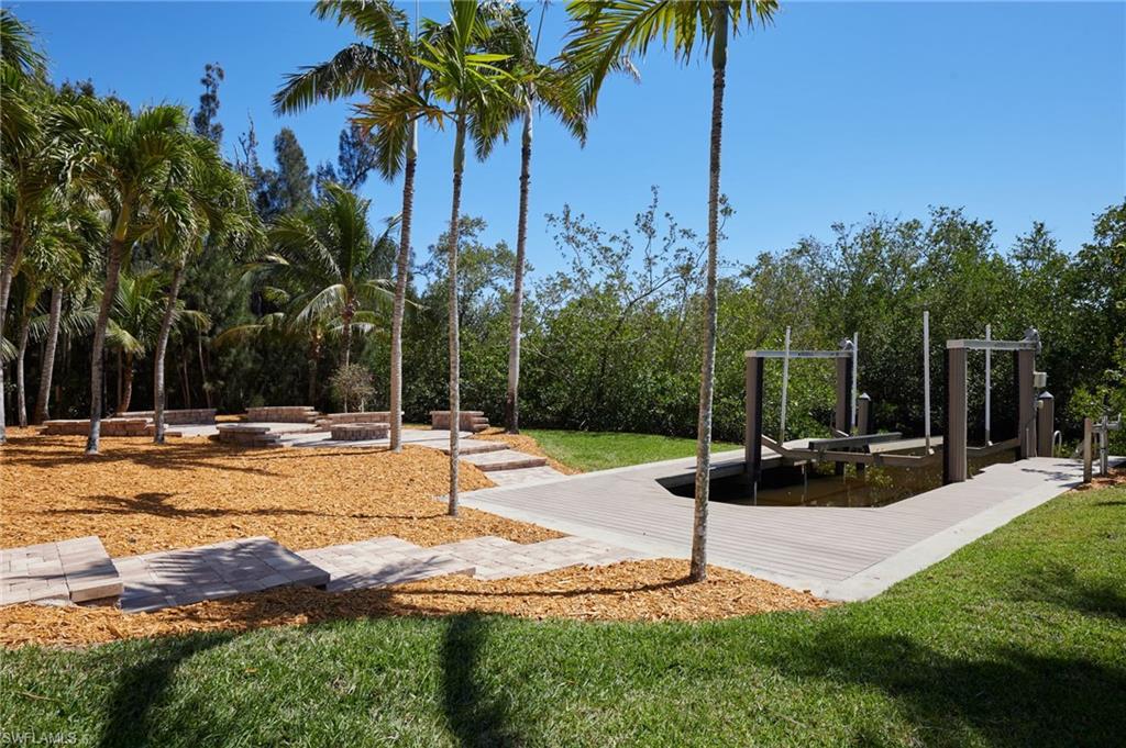 18481 Pioneer Road Fort Myers, FL 33908 - Photo 31 of 44 View of the backyard with paver patio, seating, firepit and boat dock with lift.