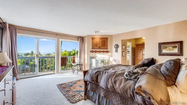 a bed sitting in a spacious bedroom next to a window