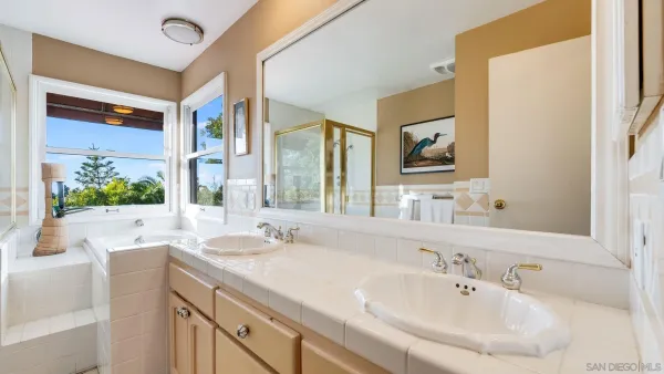 a bathroom with a tub sink and mirror