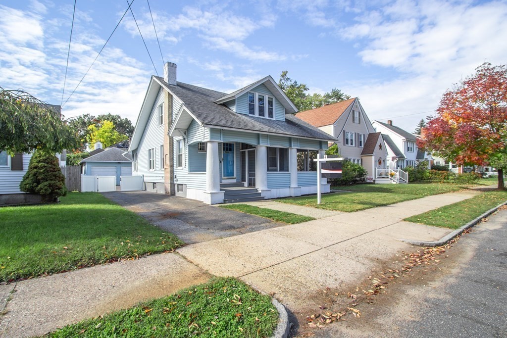 a front view of a house with a yard and trees