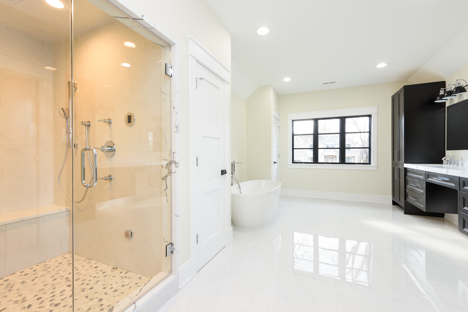1031 Prairie Lawn Road Glenview, IL 60025 - Photo 7 of 11 a spacious bathroom with a double vanity sink a shower and a mirror