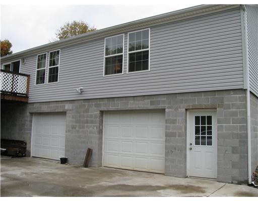 686 Venetia Road Venetia, PA 15367 - Photo 16 of 18 Exterior Back. view of the garages and man door to garage, concrete pad and driveway. There is a man door to basement under deck (not visible in this picture)