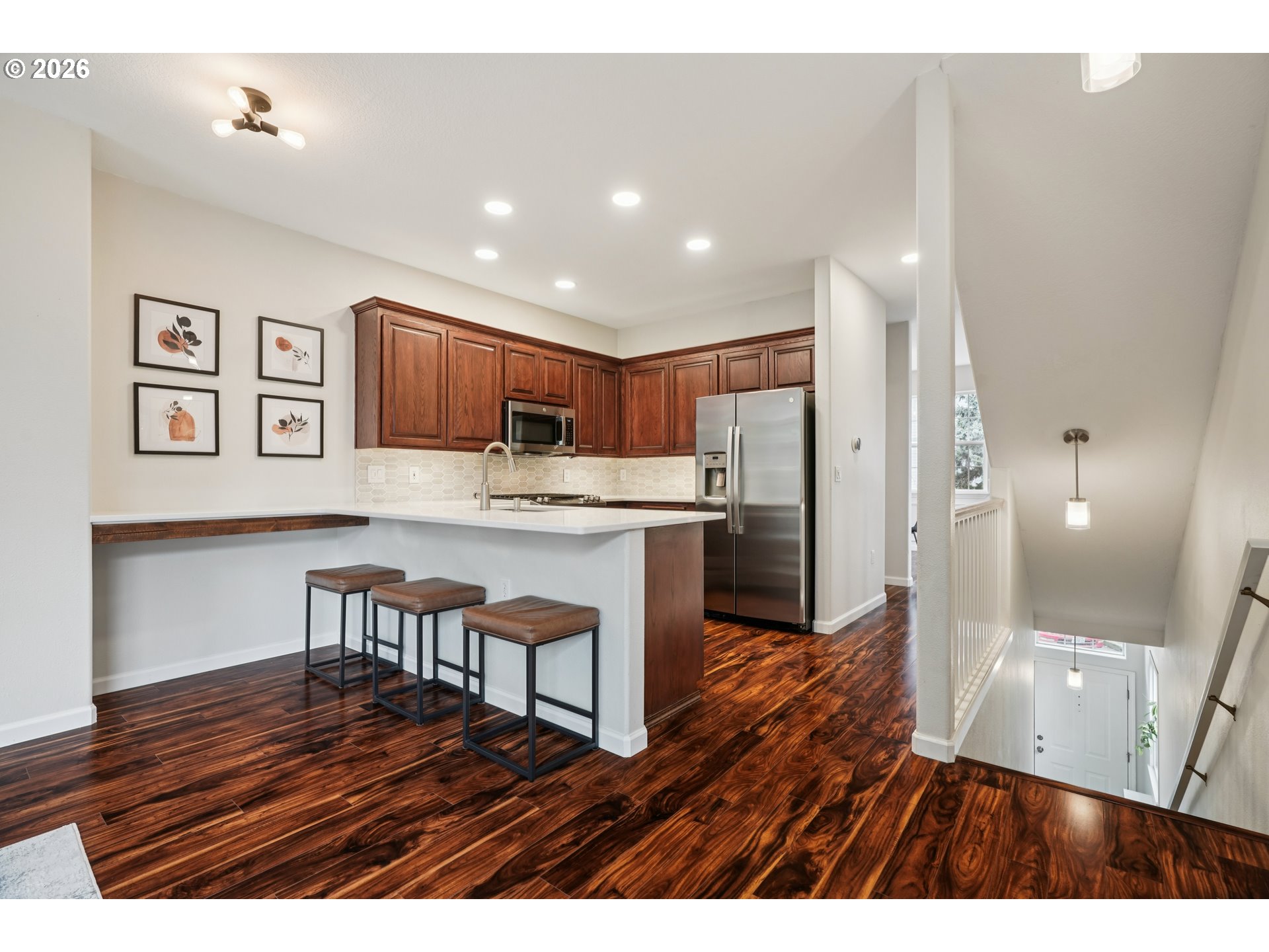 4818 Southwest 2nd Court Portland, OR 97239 - Photo 8 of 26 a open kitchen with kitchen island a refrigerator stove a sink and a dining table with wooden floor