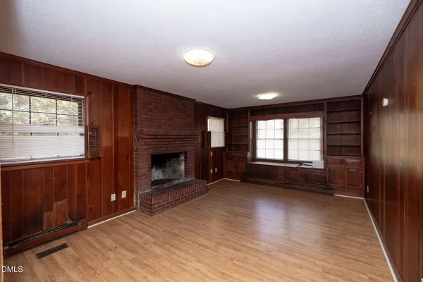an empty room with windows and a fireplace