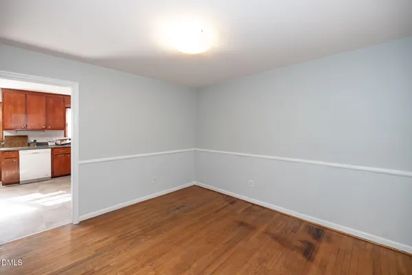 a view of a big room with wooden floor and windows