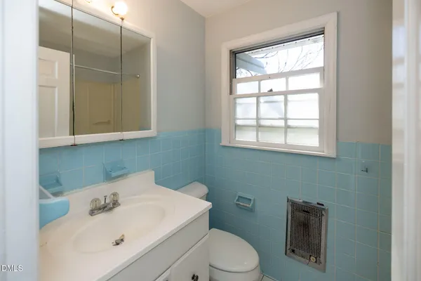 a bathroom with a sink a toilet and mirror