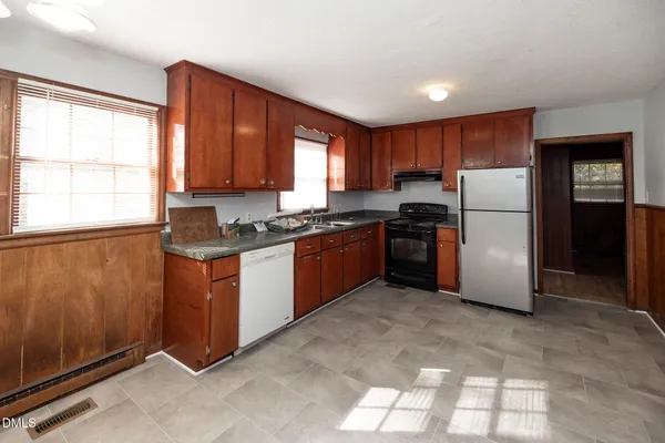 a kitchen with stainless steel appliances granite countertop a refrigerator a sink a stove a microwave and island