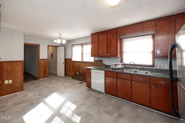 a large kitchen with kitchen island granite countertop a refrigerator and a sink