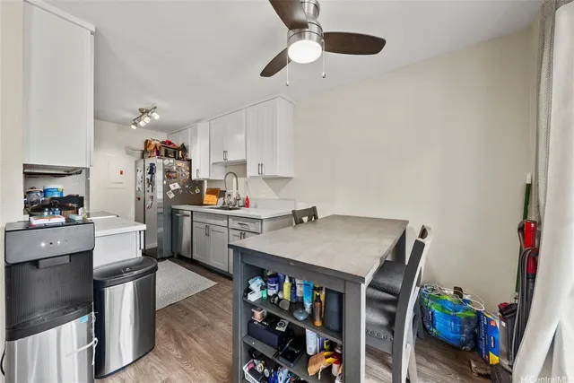 a kitchen with stainless steel appliances a stove a chimney a sink and cabinets