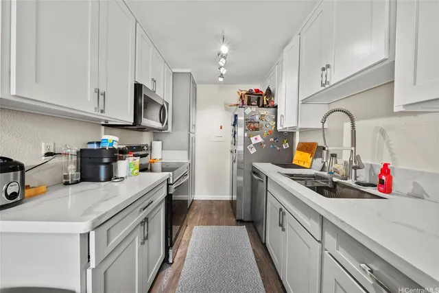 a kitchen with a sink dishwasher a stove and a refrigerator with wooden cabinets