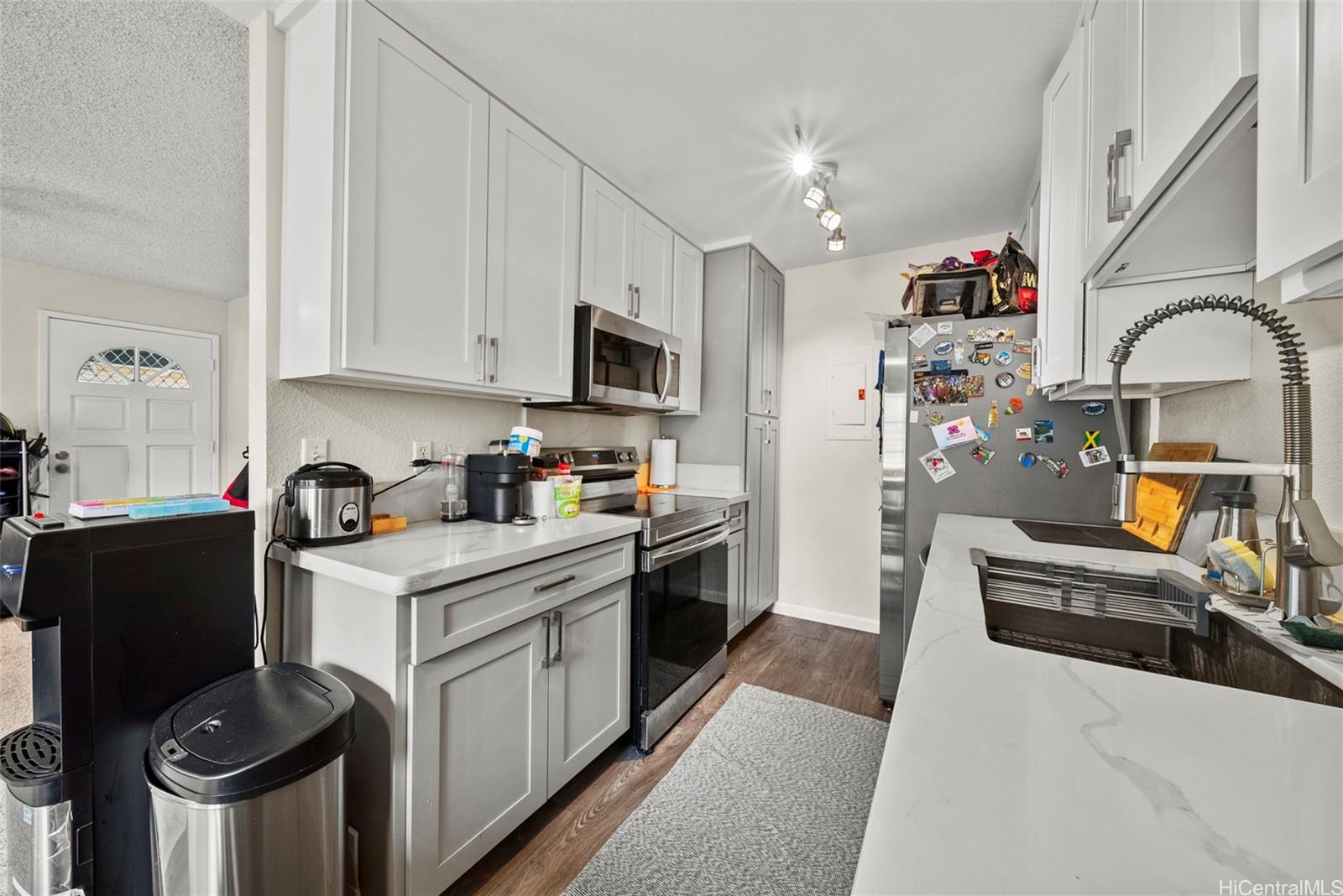 429 Mananai Place, Unit 39U Honolulu, HI 96818 - Photo 9 of 23 a kitchen with stainless steel appliances granite countertop a stove a sink dishwasher and a refrigerator with wooden floor