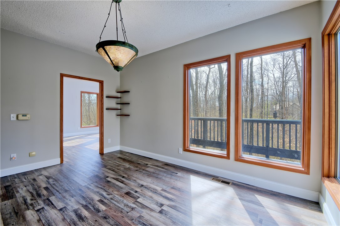 8711 Nicole Lane Springboro, OH 45066 - Photo 17 of 87 This airy room features rich wood flooring and expansive windows with a lush wooded backdrop.