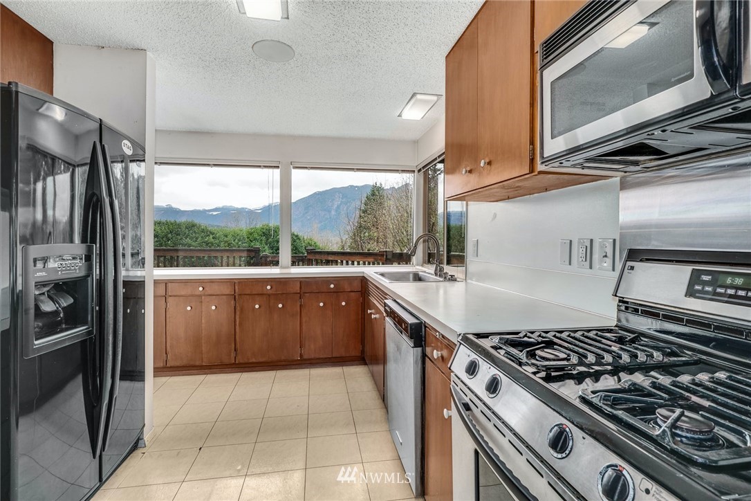 38131 Southeast 91st Street Snoqualmie, WA 98065 - Photo 12 of 40 a kitchen with a stove a refrigerator and a sink
