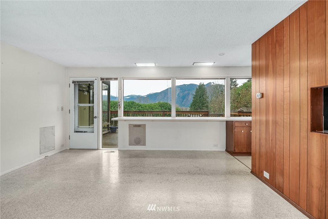 38131 Southeast 91st Street Snoqualmie, WA 98065 - Photo 10 of 40 an empty room with large windows and kitchen view