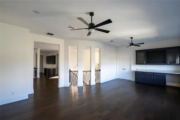 a view of room with wooden floor and ceiling fan