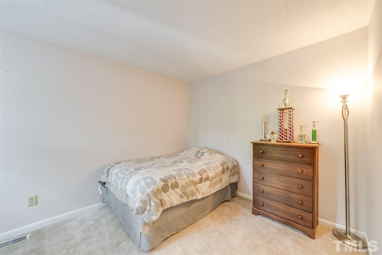 6006 Farm Gate Road Raleigh, NC 27606 - Photo 16 of 21 a bedroom with a bed and a dresser