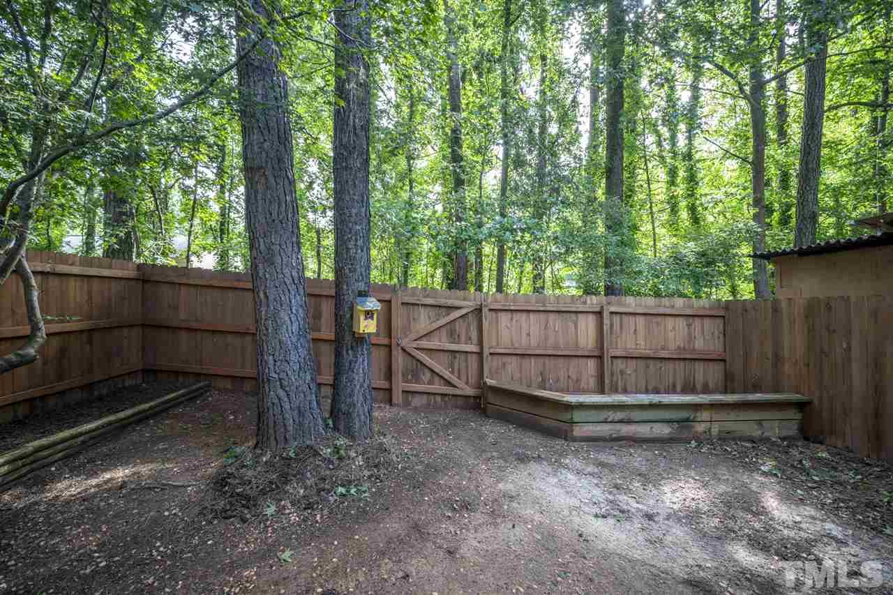 6006 Farm Gate Road Raleigh, NC 27606 - Photo 19 of 21 a view of a backyard with large trees and wooden fence