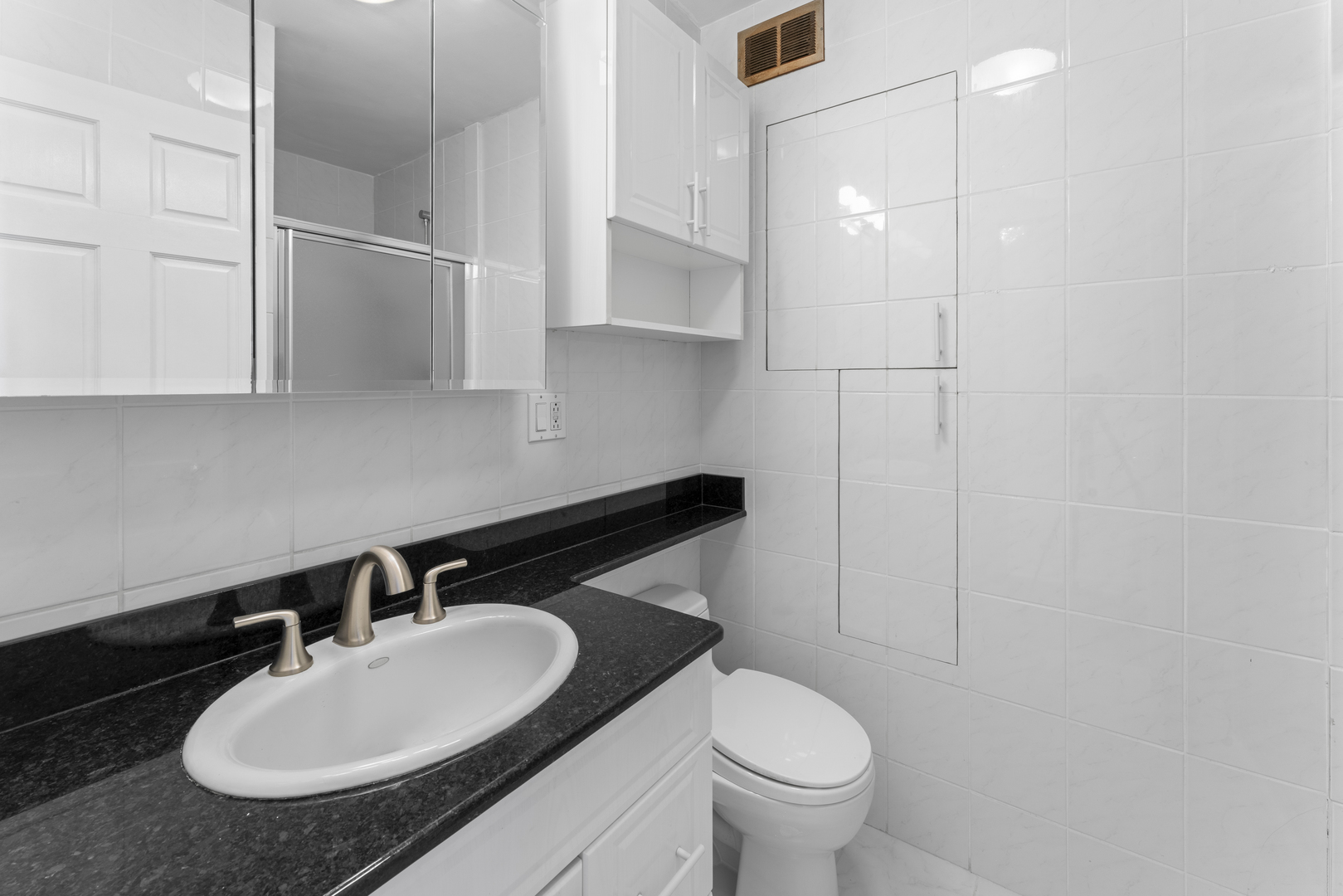 6301 North Sheridan Road, Unit 11R Chicago, IL 60660 - Photo 12 of 17 a bathroom with a sink a toilet and a mirror