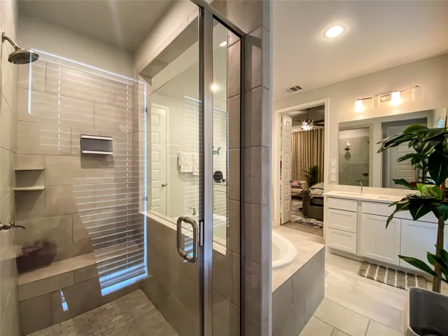 a bathroom with a bathtub a sink a mirror and shower