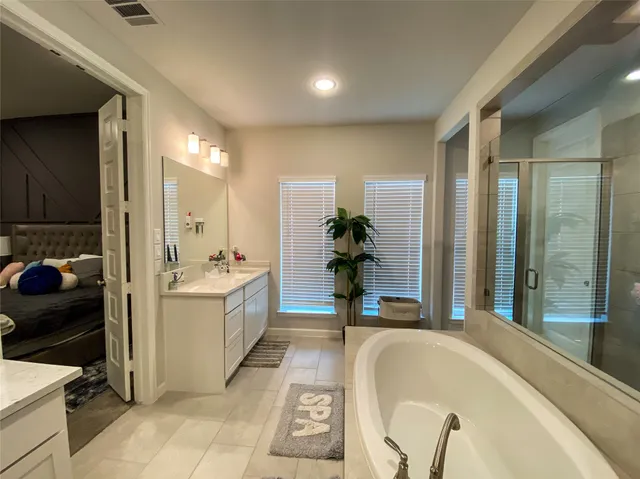 a bathroom with a tub sink and mirror