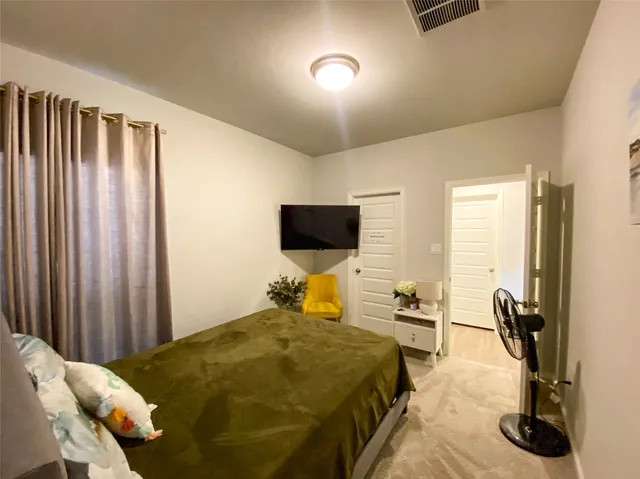 a bedroom with a bed and flat screen tv