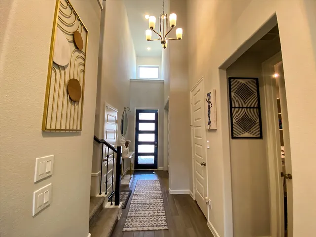 a view of a hallway with entryway and wooden floor